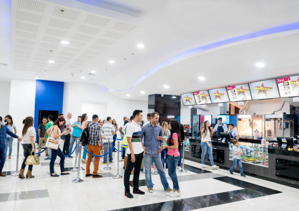 People buying food at the cinema before watching a movie Casual people buying food at the cinema before watching a movie - entertainment concepts. Image on screens were designed by us from scratch concession stand stock pictures, royalty-free photos & images