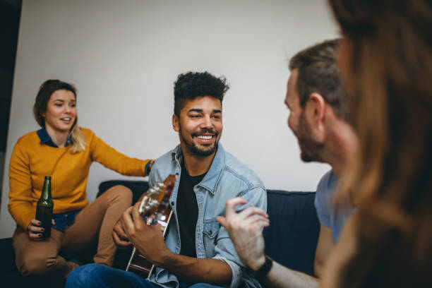 istock Young handsome man playing guitar to his friends 688789976