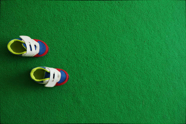 istock Baby boy shoes  on a green carpet background. 688796824