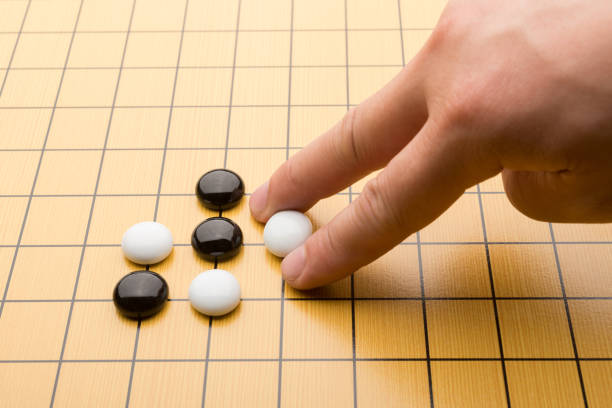 istock hand putting down piece of GO on board 688797732