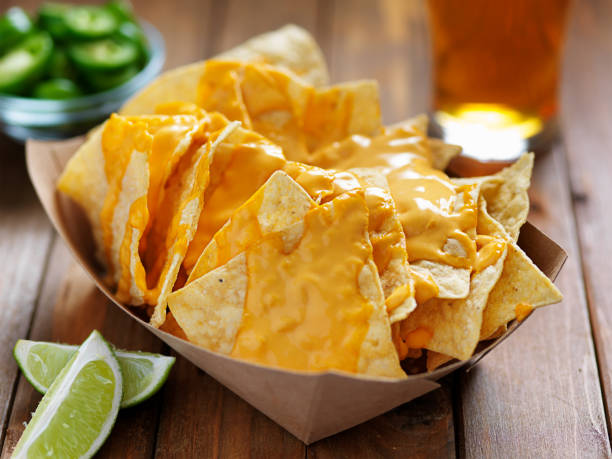 nachos and cheese in tray with beer nachos and cheese in tray with beer shot close up nacho chip photos stock pictures, royalty-free photos & images