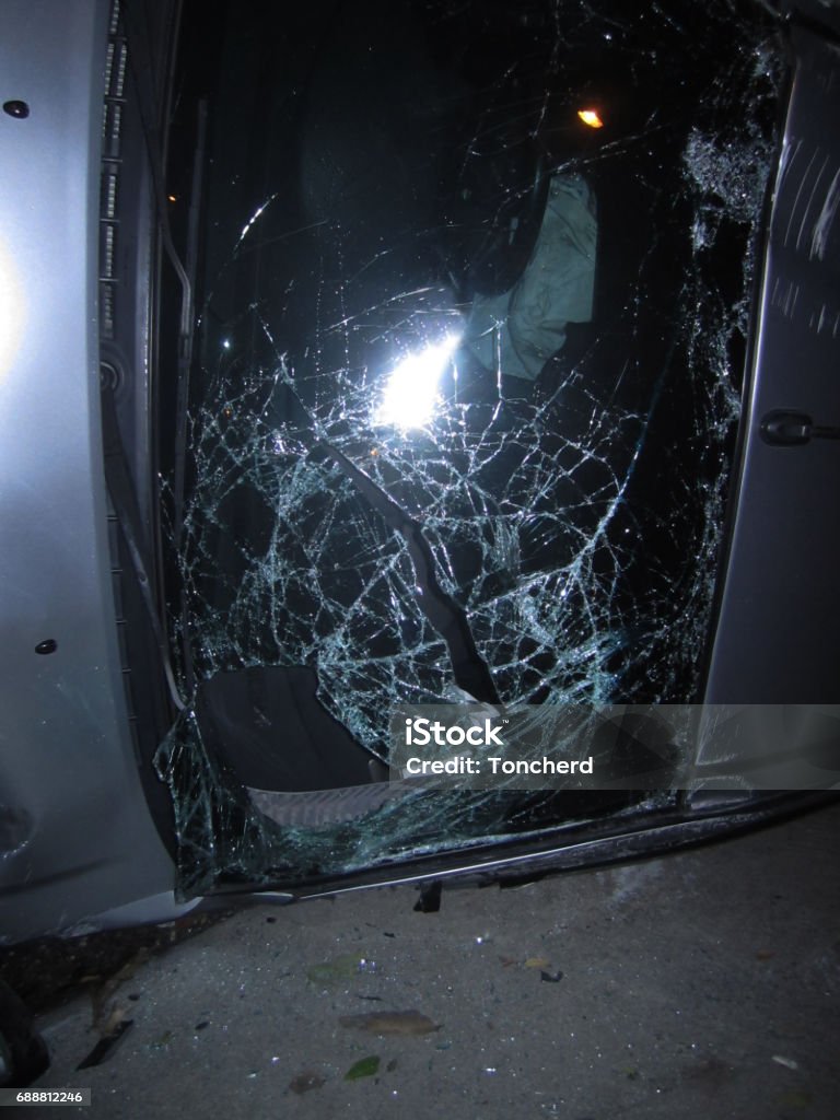 reversed car laying on the road after accident, shattered glass window of a car Accidents and Disasters Stock Photo