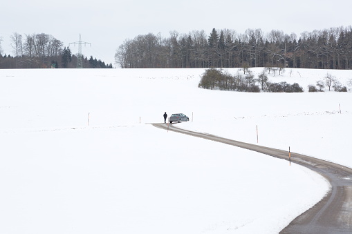 Lady makes a stop on the road to watch the winter landscape