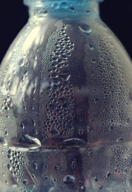 istock Many water drops on the surface of a transparent bottle on black background 688827676
