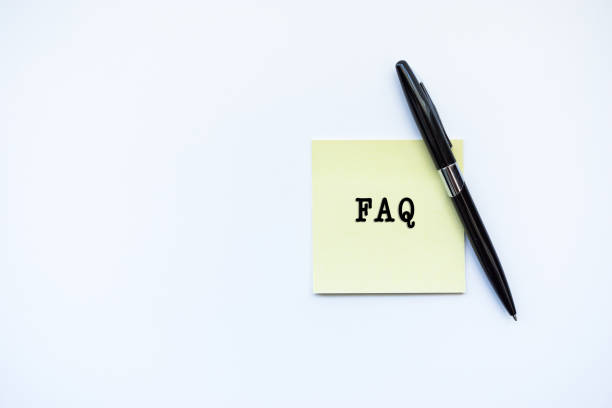 istock FAQ word concept on sticky note and a pen over top view flat lay isolated on white background. 688831028