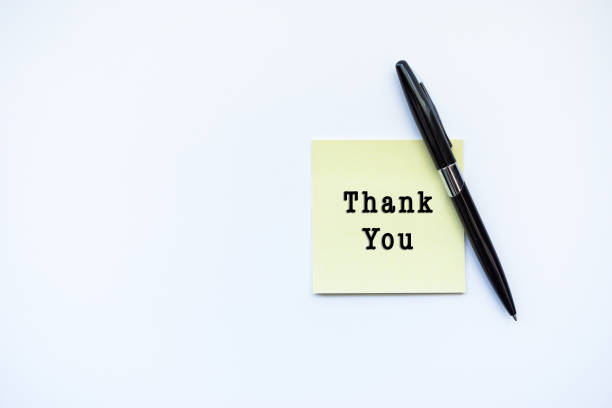 istock THANK YOU word concept on sticky note and a pen over top view flat lay isolated on white background. 688831468