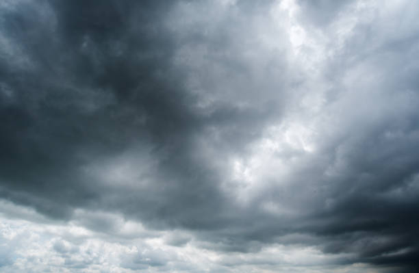 istock clouds with background,sunlight through very dark clouds background of dark storm clouds, black sky Background of dark clouds before a thunder. 688843946
