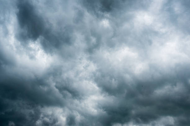 istock clouds with background,sunlight through very dark clouds background of dark storm clouds, black sky Background of dark clouds before a thunder. 688843960