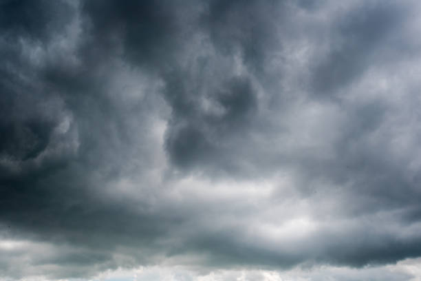 istock clouds with background,sunlight through very dark clouds background of dark storm clouds, black sky Background of dark clouds before a thunder. 688844048