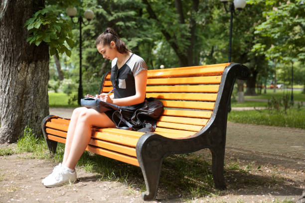 istock Young brunette woman studying in a park 688848546