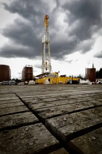 Large modern oil rig framed against a dramatic stormy sky with large amount of platform in the foreground