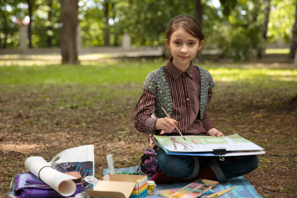 istock girl painting on easel 688848726