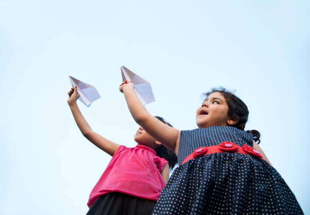 istock Girls throwing paper airplane 688859786