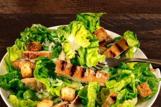 istock Closeup of chicken Caesar salad on rustic background 688862338