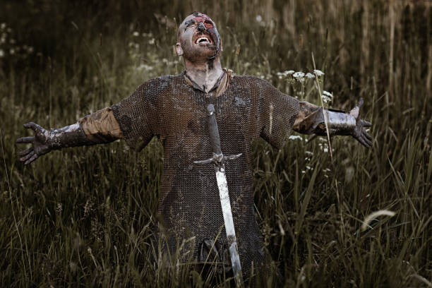 Sword wielding bloody and dirty viking warrior in countryside setting