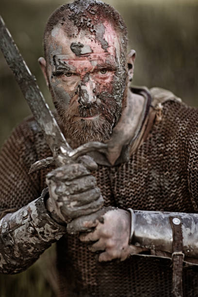istock Sword wielding bloody and dirty viking warrior in countryside setting 688869480