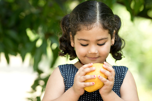 Indian girl eating mango fruit