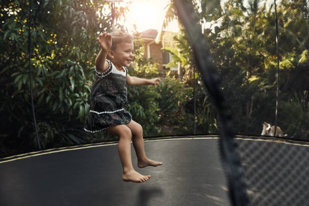 Shot of a young girl playing outside on her trampoline
