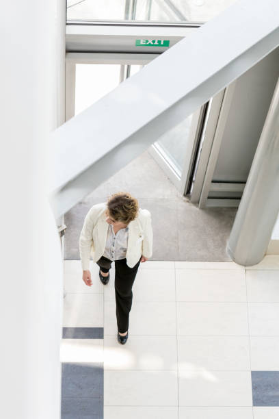 istock Businesswoman walking through lobby 688889060