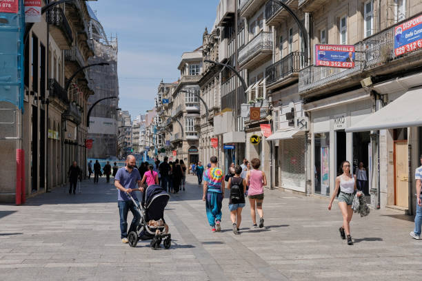 Vigo, Spain - May 26, 2017: Day shot of families walking in a downtown street in Vigo, Spain