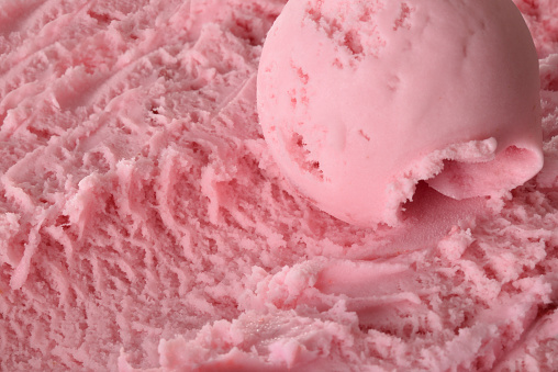 Strawberry ice cream ball on ice cream container close up. Top elevated view. Horizontal composition.