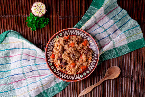 istock Pilaf on the brown plate on a wooden table, background. Rustic style.  Top view. 688901114