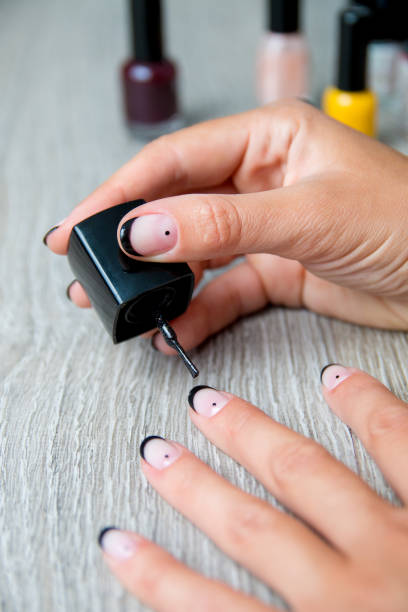 istock Black nail polish being applied to hand with tools for manicure on background. Beautiful manicure process. Close up. 688901206
