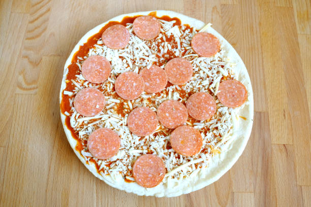 pizza cruda en cocina marrón tabla vista superior closeup - unready fotografías e imágenes de stock