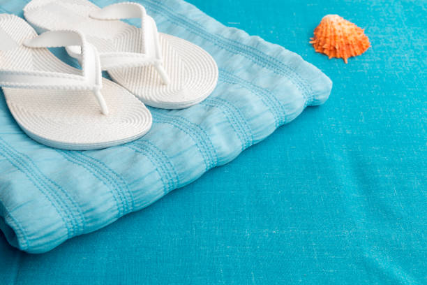 istock White flip flop near seashell on blue background. Vacation. Summer. 688911248