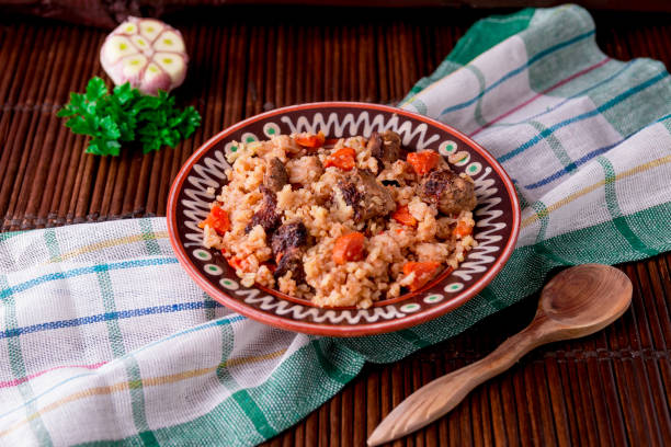 istock Pilaf on the brown plate on a wooden table, background. Rustic style. 688911360