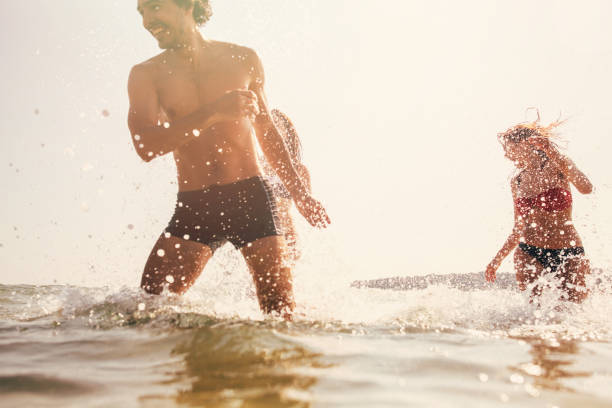 istock Friends splashing each other with water 688911774