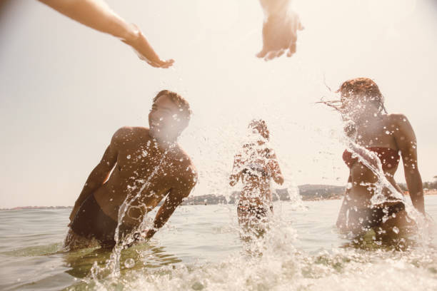 istock Friends splashing each other with water 688911782