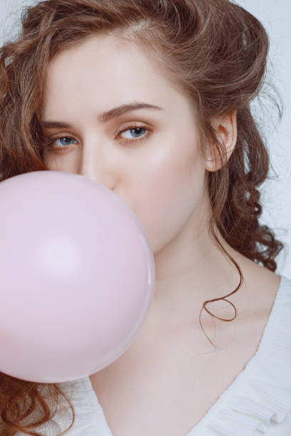 istock girl blowing bubble gum isolated on white 688925630