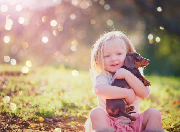 Portrait of an adorable little girl sitting with her puppy outside