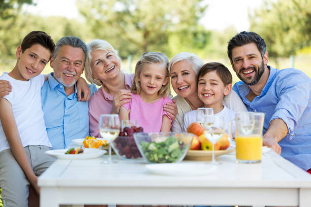 istock Family sitting at table outdoors, smiling 688938792
