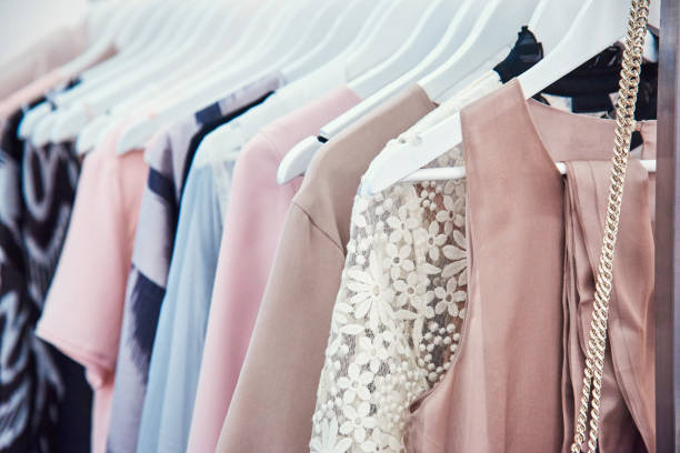 Details of bright beautiful pastel tones dress collection in show room Details of bright beautiful pastel tones dress collection in show room coathanger photos stock pictures, royalty-free photos & images
