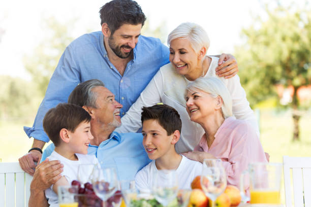 istock Family sitting at table outdoors, smiling 688955482