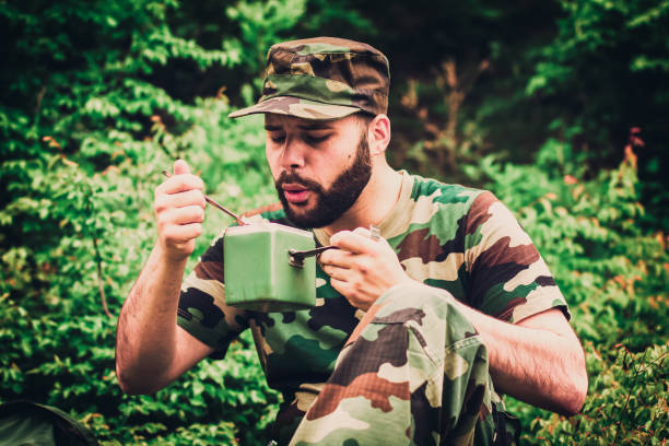 istock Young soldier eating in the forest 688958854