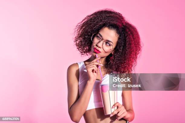 Cute Young Afro Woman Holding Drink Stock Photo - Download Image Now - Smirking, Women, One Woman Only