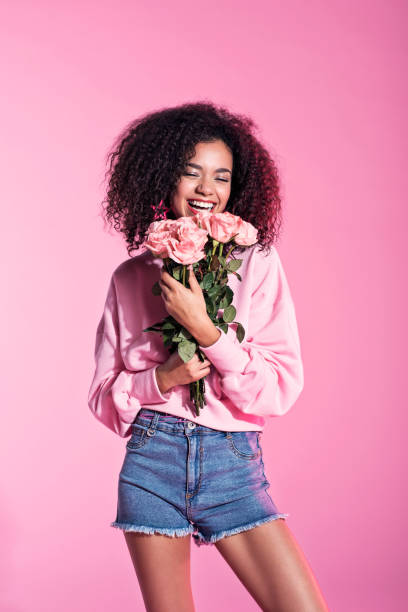 istock Cute young afro woman holding flowers 688963374