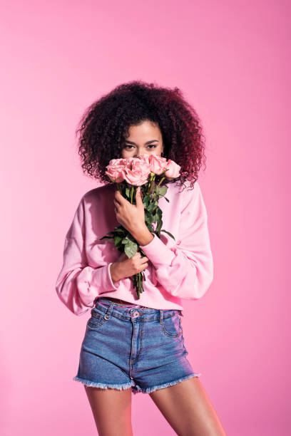 Cute young afro woman holding flowers