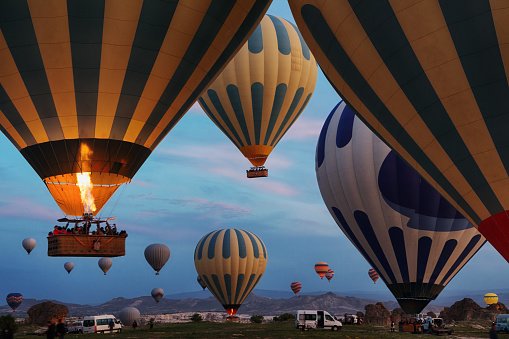 A woman travels through Cappadocia at the background of a grandiose balloon show in Turkey