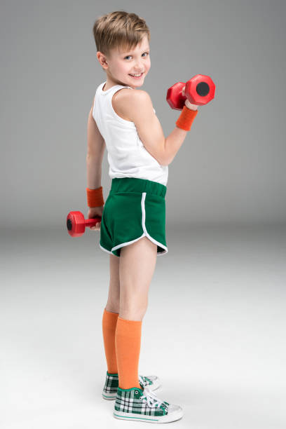 istock side view of active boy training with dumbbells isolated on grey 688967328