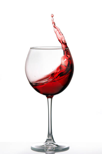 istock Glass with a splash of red wine isolated on white background 688969586