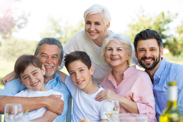 istock Family sitting at table outdoors, smiling 688973986