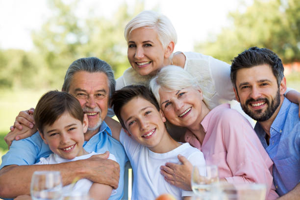 istock Family sitting at table outdoors, smiling 688974046