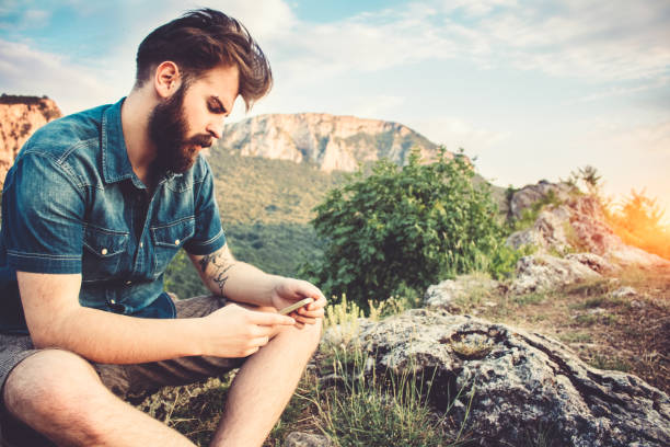 istock Bearded guy with phone in the mountains 688986906
