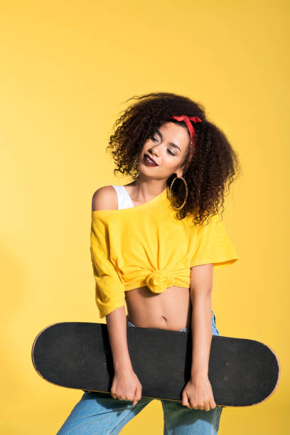 istock Young afro woman holding skateboard 688993860