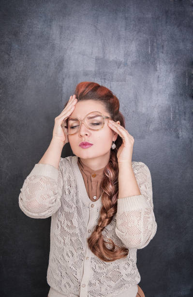 istock Beautiful teacher with headache on the chalkboard background 688993880