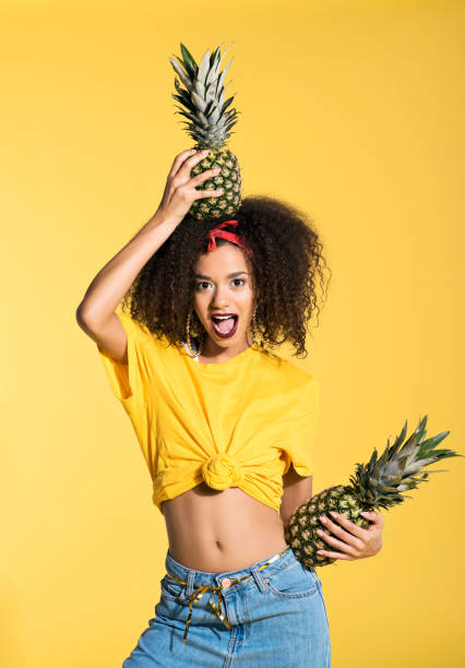 istock Surprised young afro woman holding pineapples 688997182
